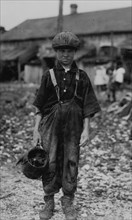 Henry, 10 year old oyster shucker who does five pots of oyster [sic] a day. Works before school, after school, and Saturdays. Been working three years. Maggioni Canning Co.  1912