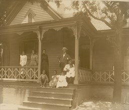 Home of an African American lawyer, Atlanta, Georgia, with men, women, and children posed on porch of house 1899