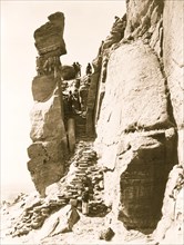 Hopi Indians along steps up rocks, leading to pueblo on mesa, Walpi, Arizona. 1879