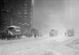 Horse-drawn wagons on snowy street, NY snow storm 1910