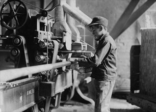 Indiana Mfg. Co., Boy taking boards away from "double cut-off" machine. 1908