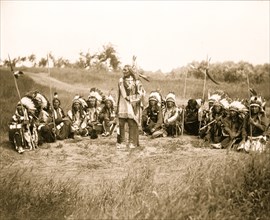 Chief Little Wound in council with other Indians, wearing feather headdresses 1899