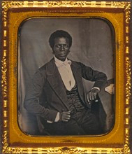 James M. Priest, three-quarter length portrait, full face, seated at desk 1857