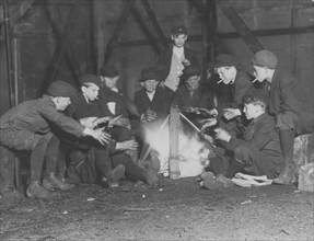 Jefferson St. Gang of newsboys at 10:00 P.M. over campfire in corner lot behind bill-board.  1910