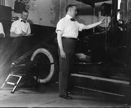 John Drennen of the New York City Mayor's Bureau of Licenses inspecting a taxicab meter after new ordinance regulating meters went into effect on August 1, 1913. 1913