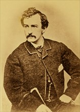 John Wilkes Booth, half-length portrait, facing left and holding a cane 1860