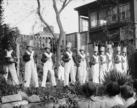 Line of Boys pose as Soldiers with inverted pails on their heads 1923