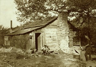 little log cabin, - relic of the old days, - now occupied by a small family (F. T. Castle) who are gradually giving up farming and depending upon mining and odd jobs. Oct. 12, 1921. (Dogs). Location: ...