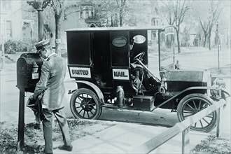 Mailman at Post Box with his truck parked at the curb 1925
