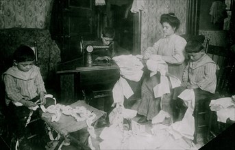 Making dresses for Campbell Kid Dolls in a dirty tenement room 1912