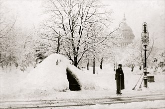 Man standing by snow hut, after blizzard of 1888, with U.S. Capitol in background, Washington, D.C. 1888