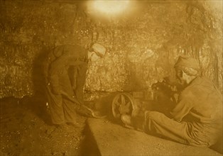 Man with punching machine to drill into coal.  1908