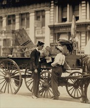 Messenger boys in conversation at Union Square, N.Y. Location: New York, New York 1910