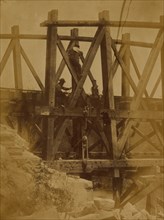 Military railroad operations in northern Virginia: two men boring holes in bridge trestles and man with Haupt's Torpedo 1863