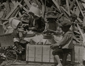 Mother and children hulling strawberries at Johnson's Hulling Station.  1911