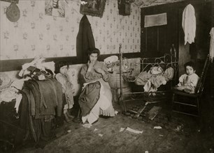 Mrs. Guadina, living in a dirty poverty-stricken home, and making a pittance by finishing pants.  1912