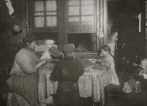Italian family packing nuts in their tenement apartment 1911
