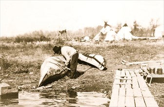 Mending his canoe 1913