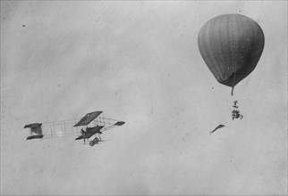 Paulhan in aeroplane greets his wife in a balloon, both in flight