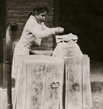 Looking for unburned coal in an ash barrel 1910