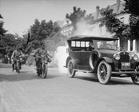 Police on motorcycles trailing car with smoke 1923