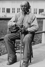 Portrait of an Male Ex-Slave Sitting in Chair & Smoking 1920