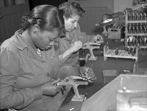 Production. Aircraft engines. Black women with no previous industrial experience are reconditioning used spark plugs in a large Midwest airplane plant. 1942