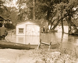 River overflows into garage; canoes set on the banks 1924