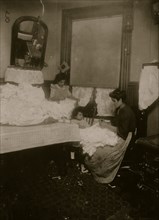 Italian girl helps her Mother make corset covers in their tenement apartment 1911