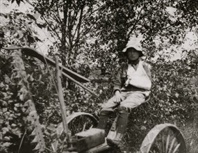 Rural Accident. Twelve-year old Clinton Stewart and his mowing machine which cut off his hand. 1915