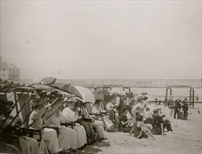 Spectators seated in beach chairs with awnings watches the motor boat races at Palm Beach, Florida 1910