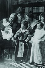Teddy Roosevelt holds a baby in his arms in a Family Portrait