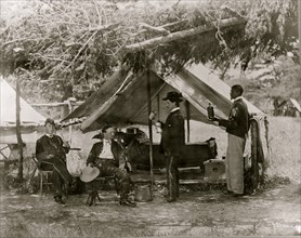 Maj. H.H. Humphrey and others dining in front of their tent