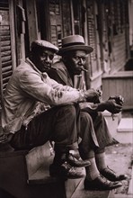 Two African American men sitting on stoop 1962