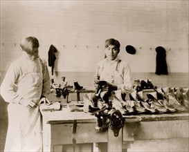 Two boys making or repairing shoes at Carlisle Indian School] 1904