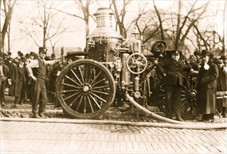 Two firemen with fire engine 1916