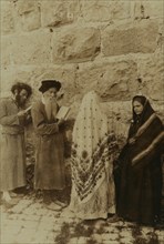 Two Jewish men and two women standing in front of the Wailing Wall, Jerusalem 1908