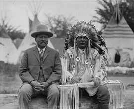 Two native American men, one in traditional dress 1923