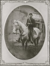 Unidentified African American soldier seated on horseback, facing left. 1865