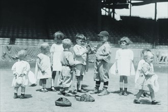 Toddlers on Baseball Field grasp a bat to select team members