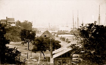 View of City Point, Virginia, with covered wagons moving toward pier and harbor in background 1864