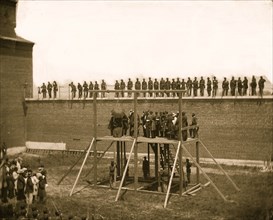 Washington, D.C. The four condemned conspirators (Mrs. Surratt, Payne, Herold, Atzerodt), with officers and others on the scaffold; guards on the wall 1865