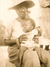 Woman holding child on her lap, Old Bight, Cat Island, Bahamas 1935