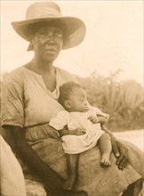 Woman sitting and holding infant, Cat Island, Bahamas 1935