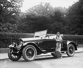 Woman wearing native American clothing next to automobile 1923