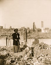 Women pick through the rubble of buildings after the earthquake 1906