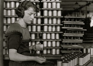 Young Girl stacks spools of silk thread 1924