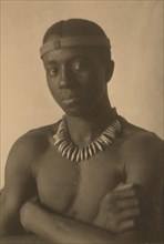 Young man with headband and necklace 1897