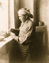 Zuni Indian bead worker drilling holes in beads 1903