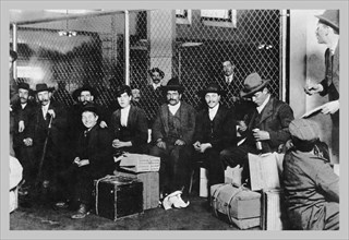 Immigrant Men Sitting at Ellis Island 1900